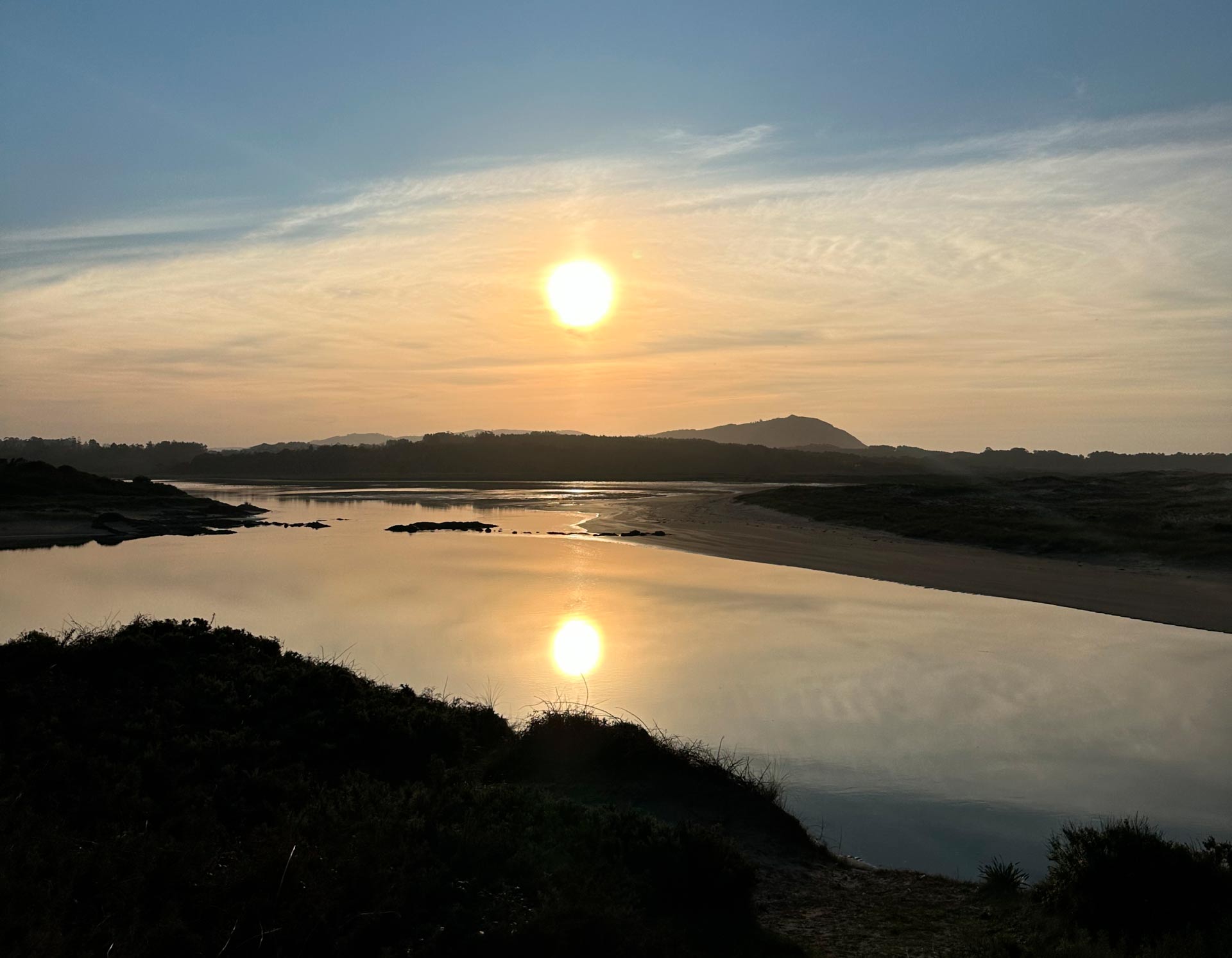 Puesta de sol en la Laguna da Frouxeira Puesta de sol en la Laguna da Frouxeira en Valdoviño con vista al paisaje natural y el océano Atlántico